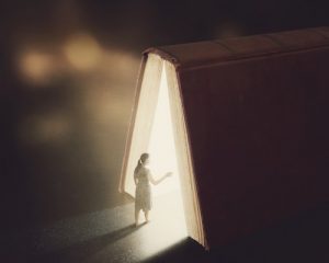 A woman walks through a big bible.